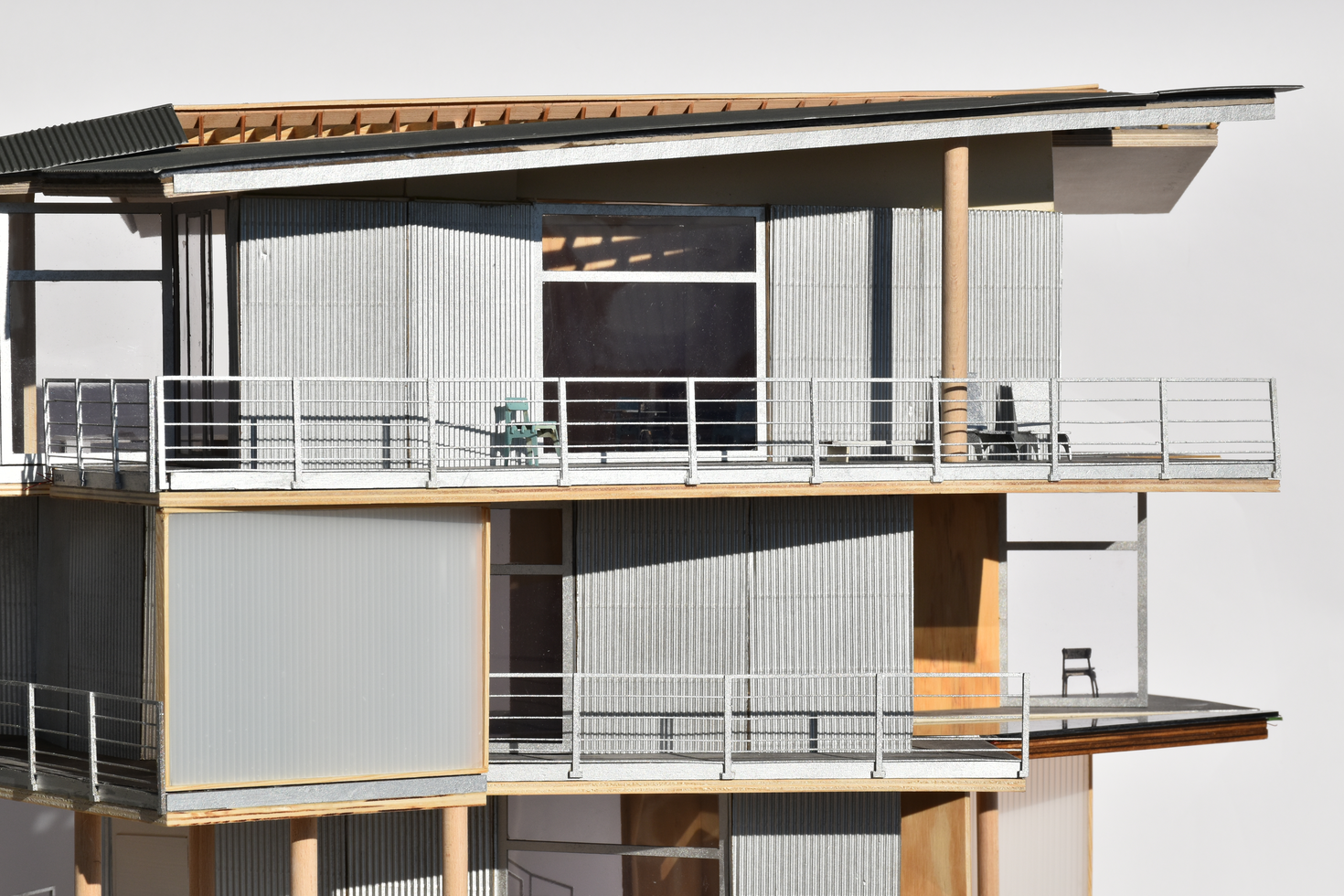 波形、バルコニー、目に見える木材構造を特徴とする木材構造の詳細な建築規模モデル。複雑なデザインと材料の選択を強調しています。