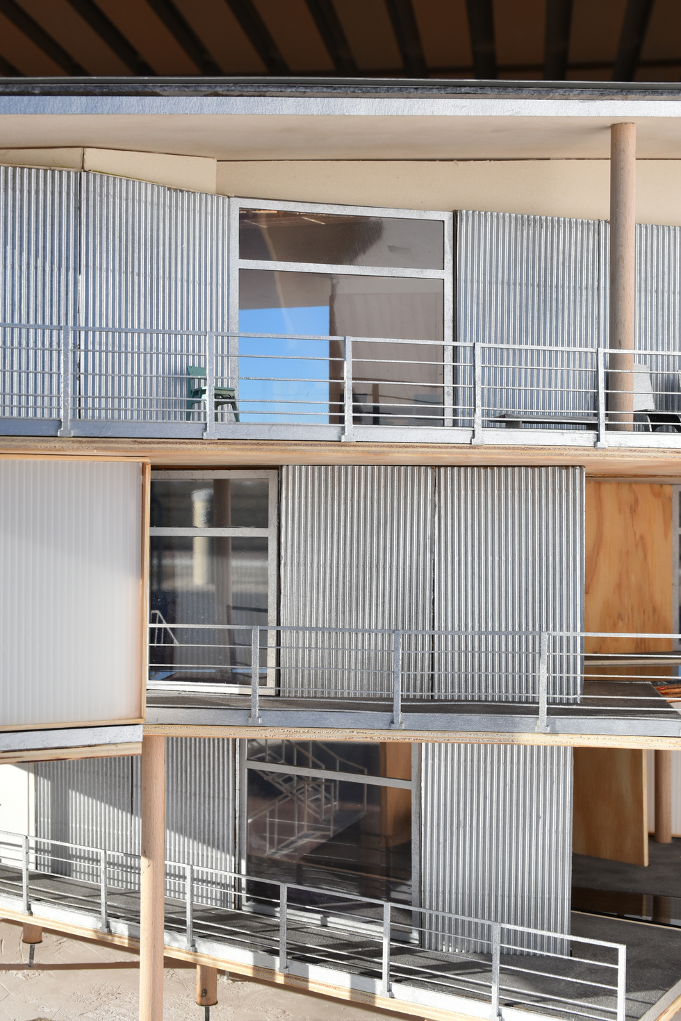 三层楼现代住宅建筑的建筑模型，其当代设计配有波纹金属覆层和杰出的木质元素。